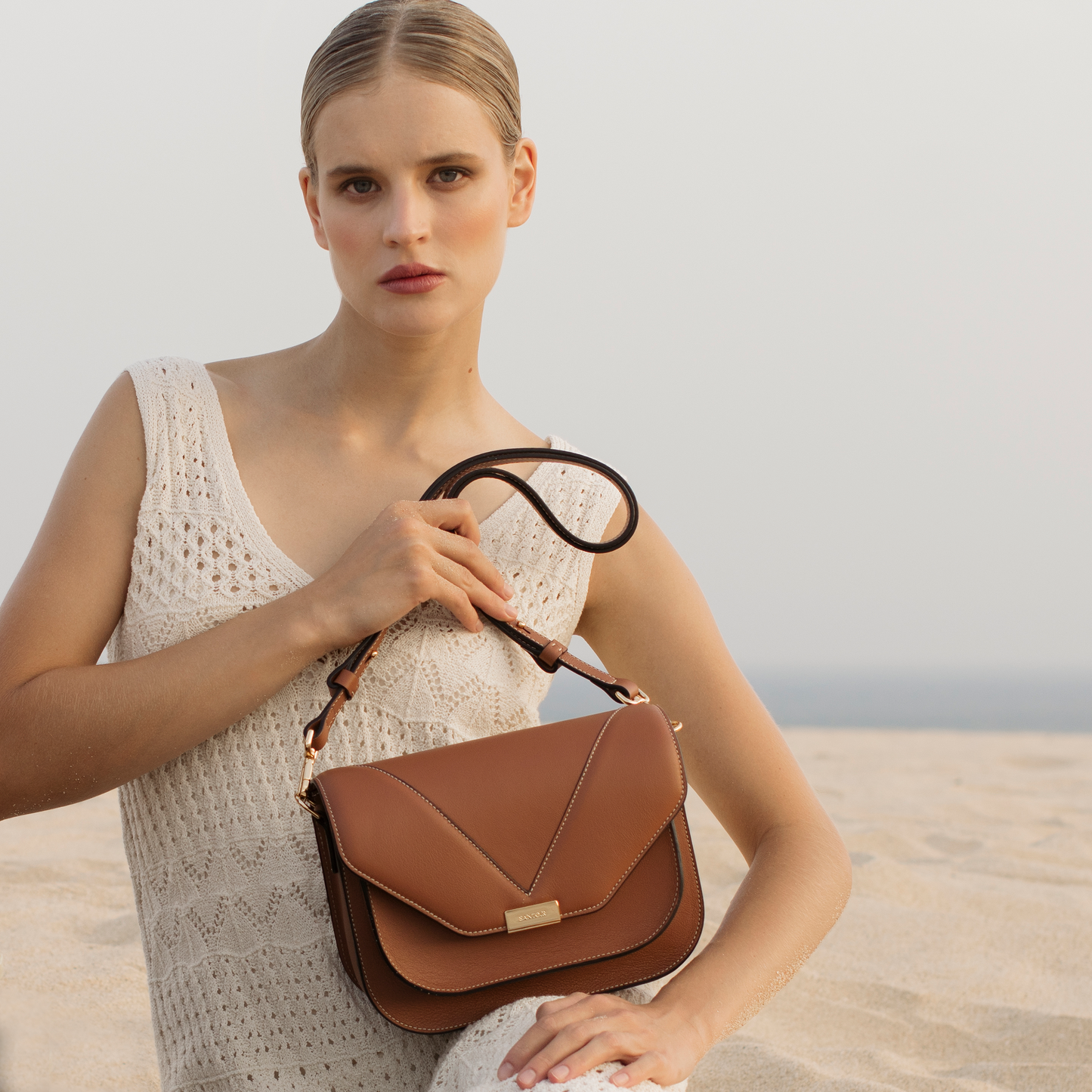Caramel leather crossbody bag worn by model, Fortuna by Santoir in smooth calfskin, structured yet refined minimalist silhouette for everyday elegance