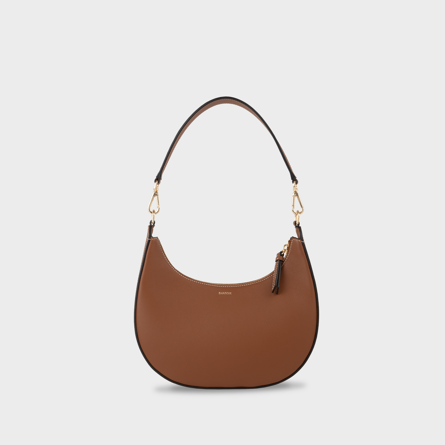 Caramel crescent moon shaped shoulder bag in smooth calfskin leather, Santoir Luna bag with short strap, warm tan semi-structured handbag handcrafted in Spain.