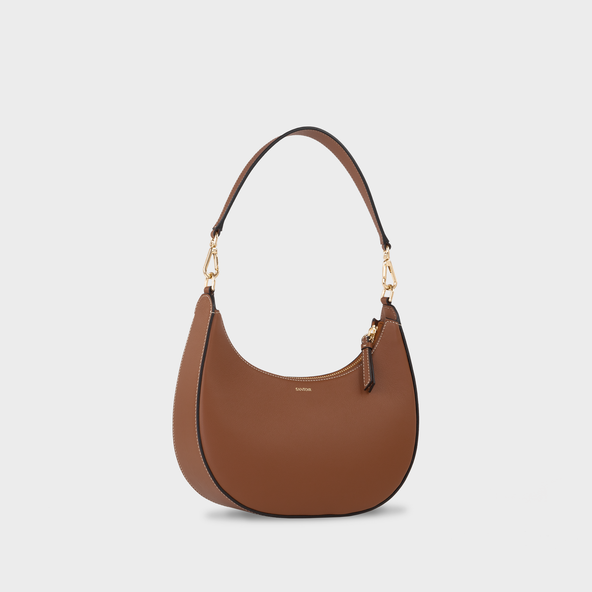 Caramel crescent moon shaped shoulder bag in smooth calfskin leather, side view of Santoir Luna bag with short strap, warm tan semi-structured handbag handcrafted in Spain.