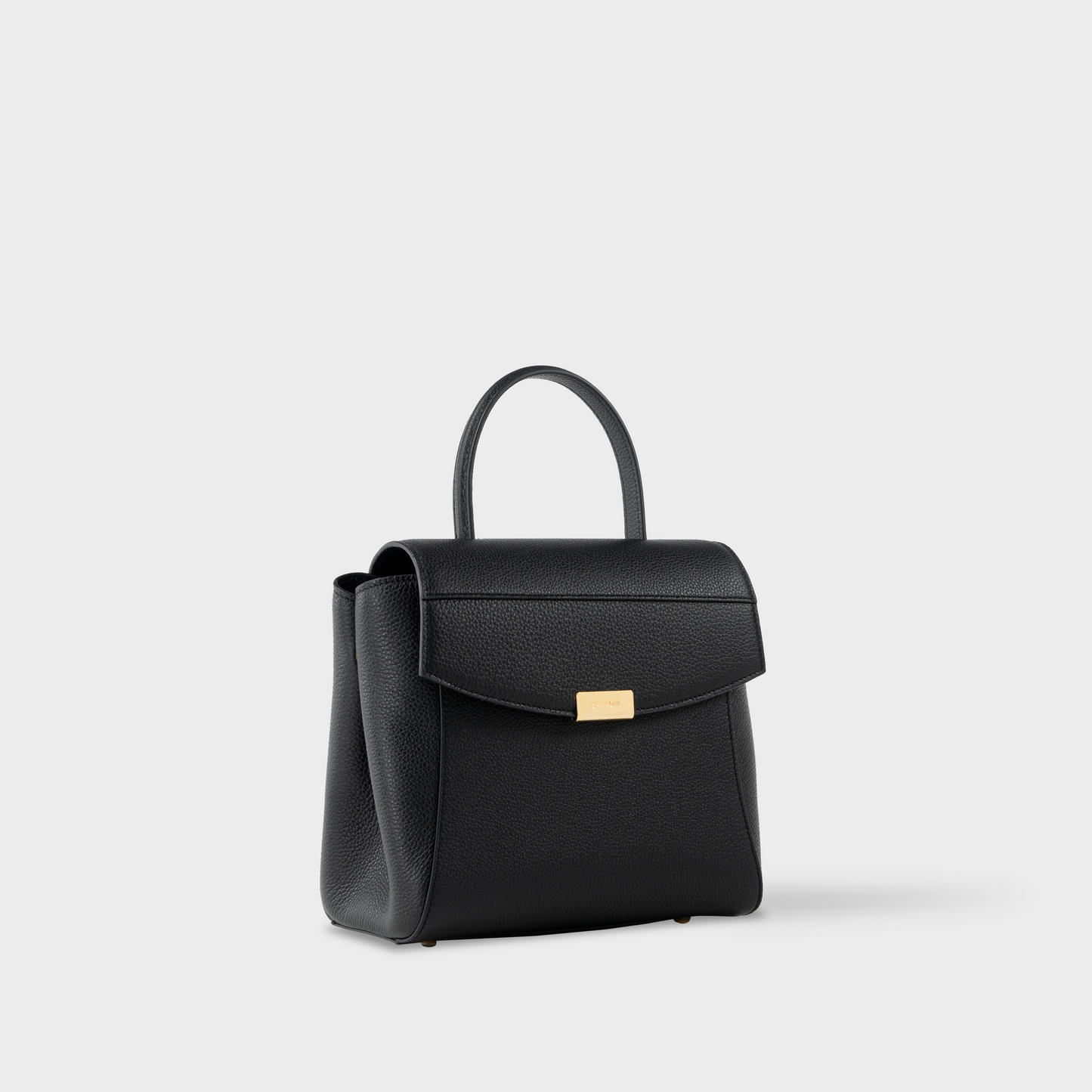 Side view of structured black leather mini bag with closed gusset, Santoir Mini Boss in pebbled calfskin showcasing compact, sculptural silhouette and clean minimalist lines, handcrafted in Spain.