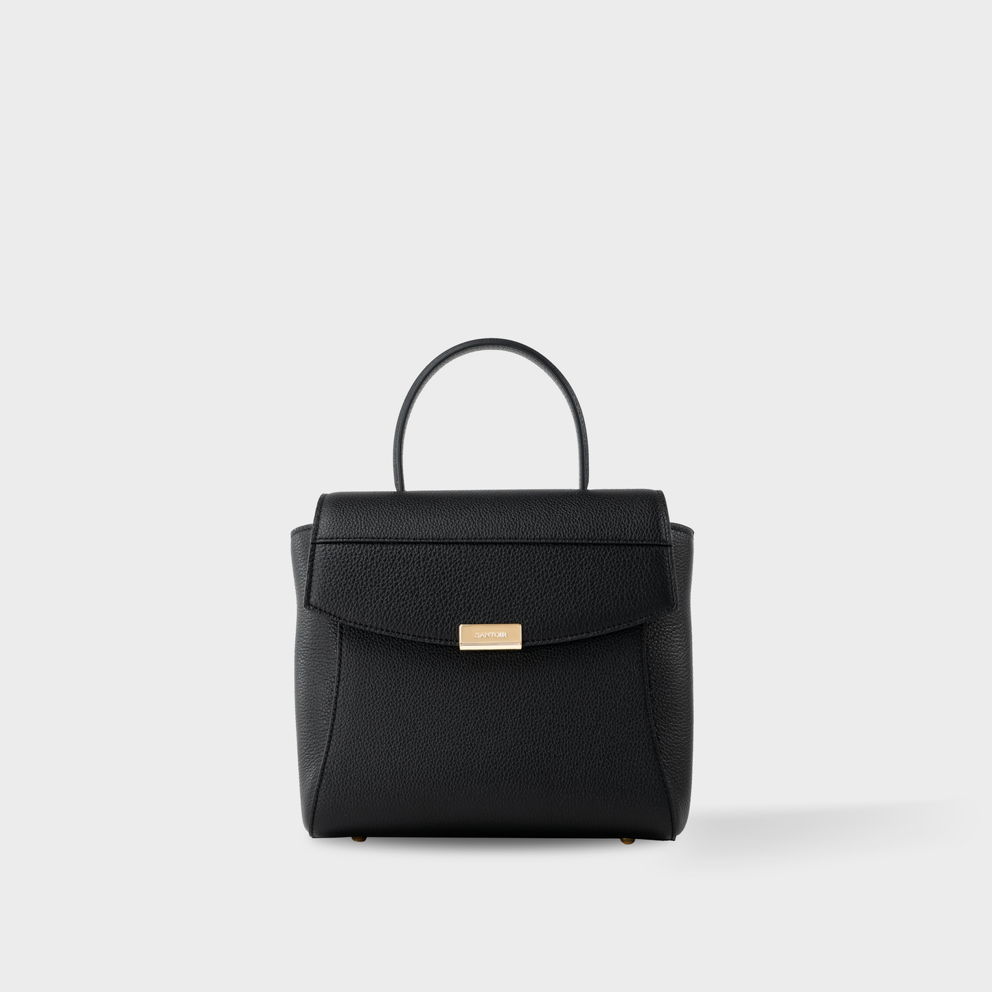 Structured black leather mini bag with closed gusset, Santoir Mini Boss in pebbled calfskin showcasing compact, sculptural silhouette and clean minimalist lines, handcrafted in Spain.