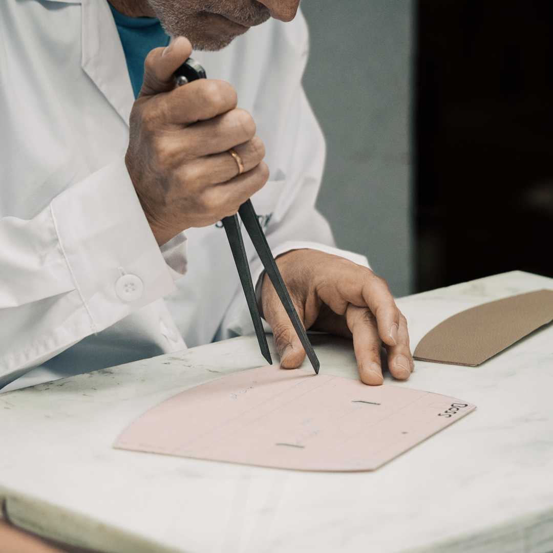 Artisan using compass over pattern to measure distance