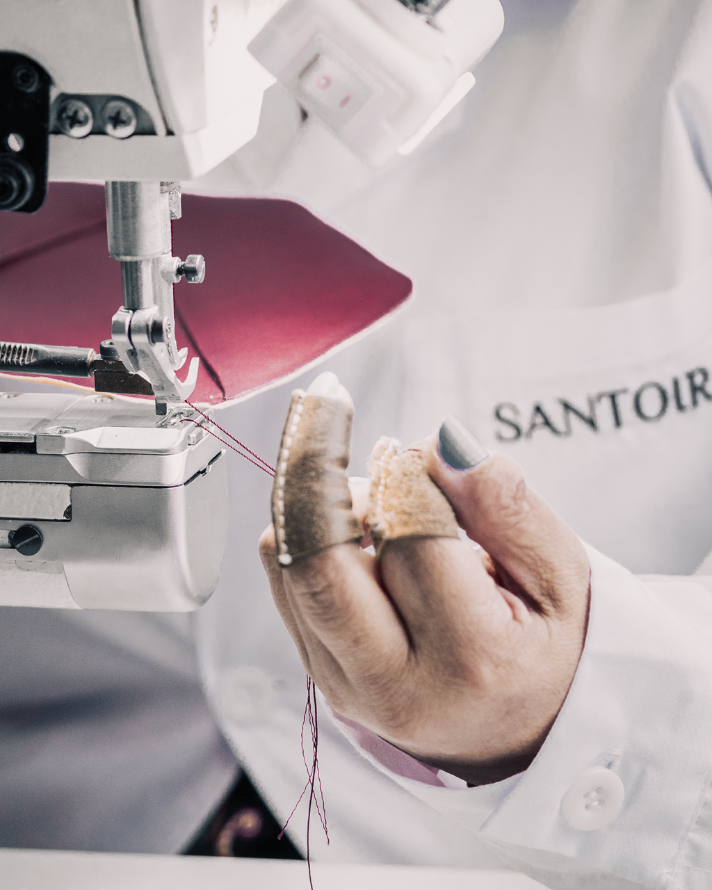 Artisan woman sewing Fortuna Bag flap in bordeaux