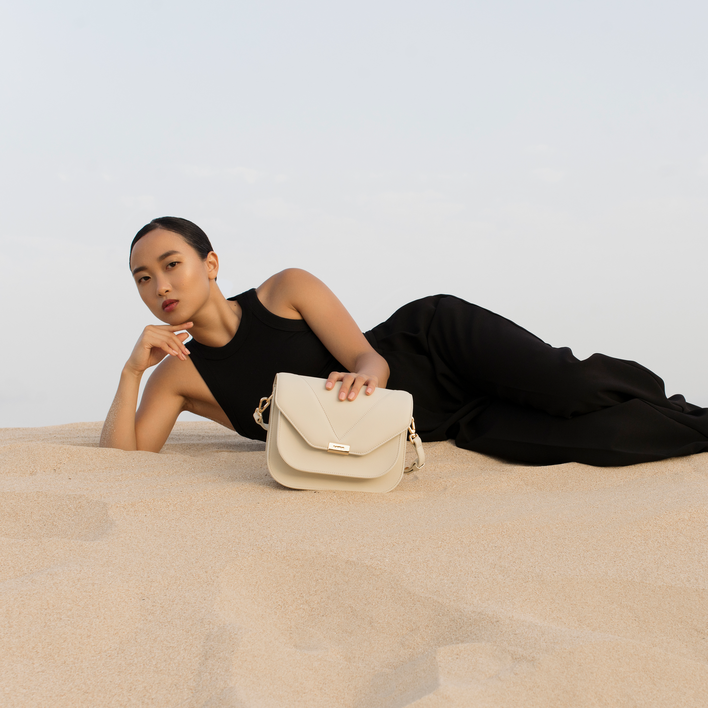 Ivory leather crossbody bag worn by model, Fortuna by Santoir in smooth calfskin, structured yet refined minimalist silhouette for everyday elegance.
