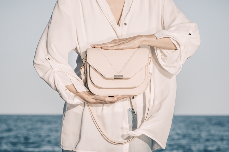 Fortuna bag in ivory color holded by a model with both hands simetrically over and under